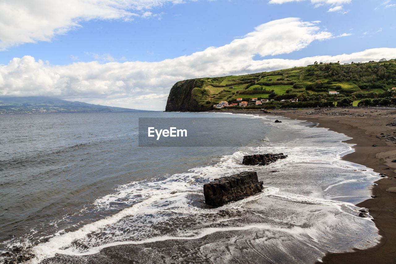 Scenic view of rocks in sea against sky