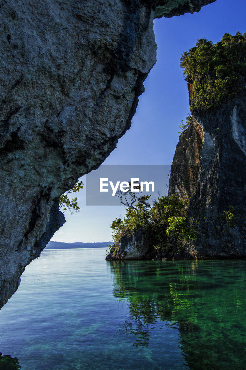 Rock formation in sea against sky