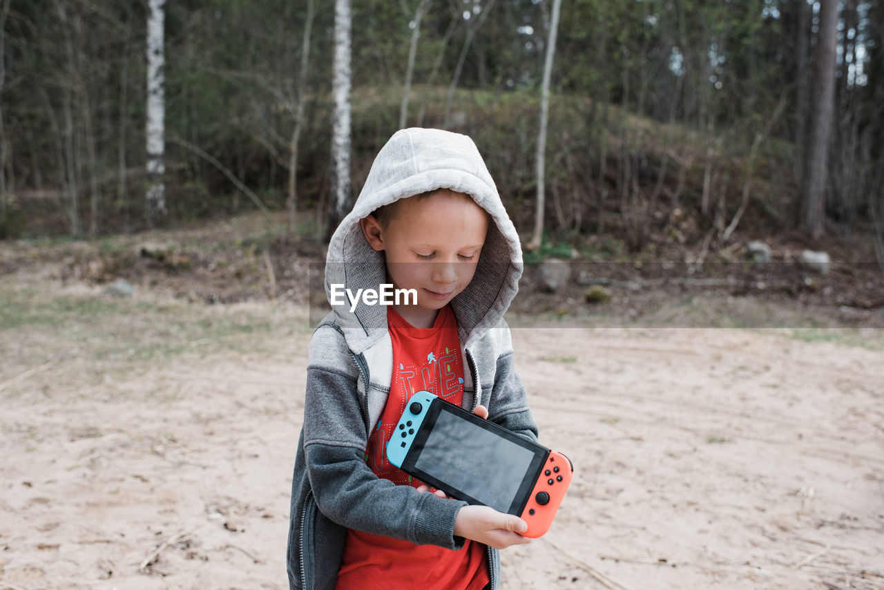 Young boy holding a nintendo games console sharing the screen