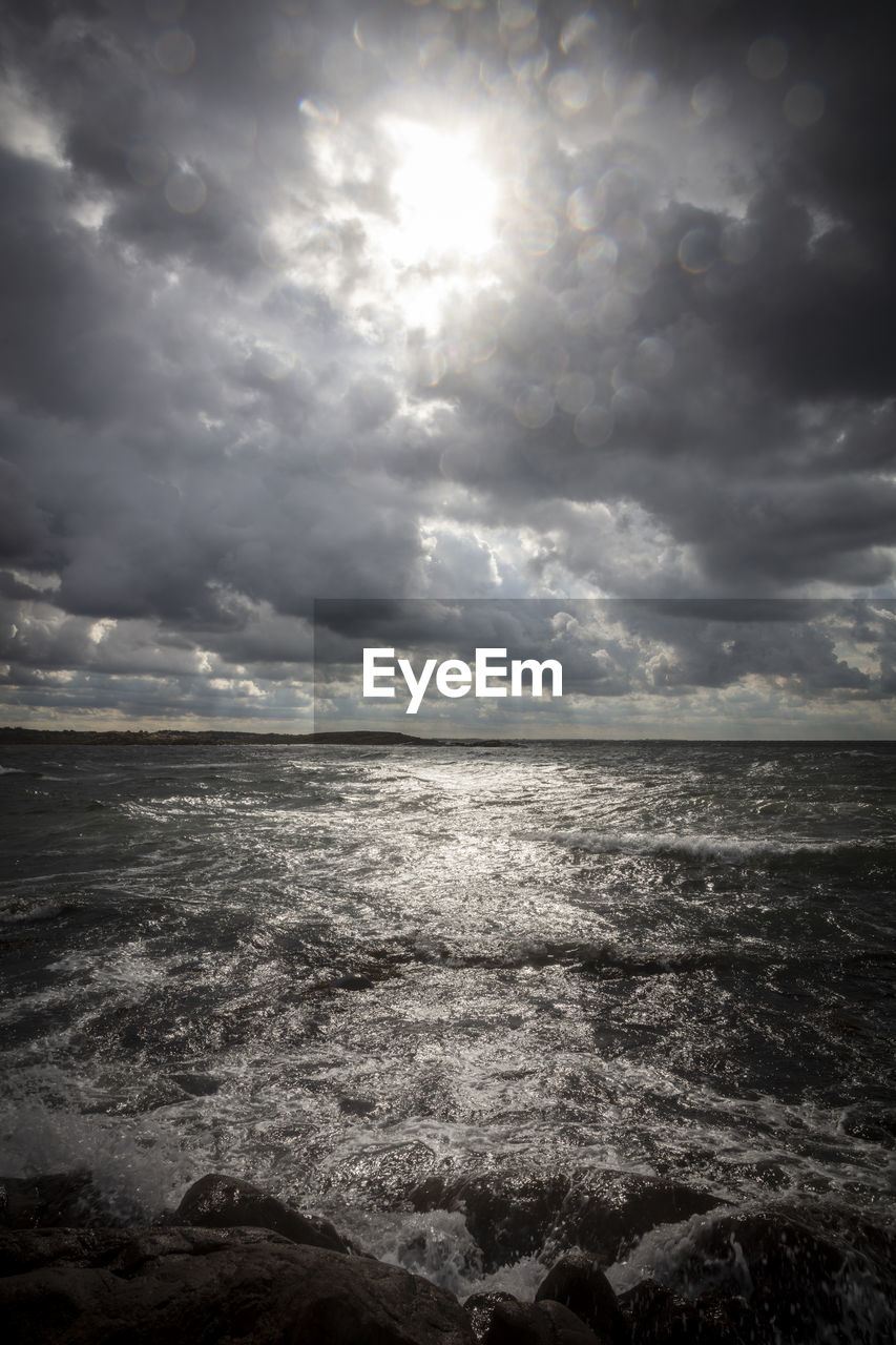 SCENIC VIEW OF BEACH AGAINST CLOUDY SKY