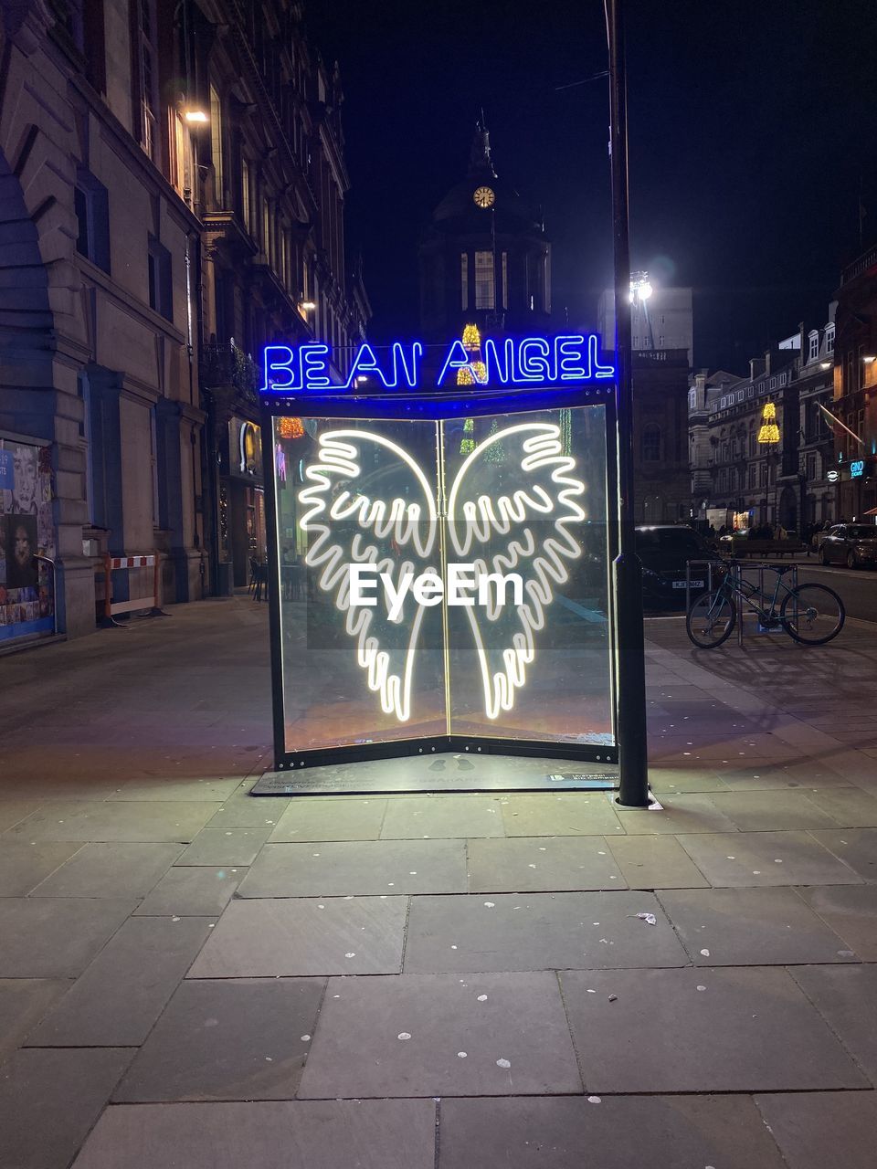 GRAFFITI ON ILLUMINATED STREET BY BUILDING AT NIGHT