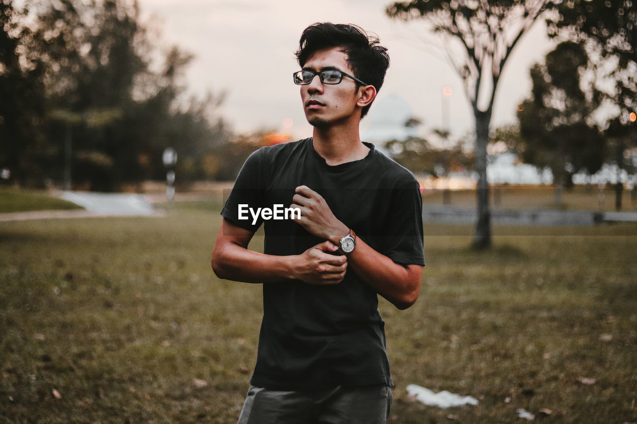 Portrait of young man standing on field