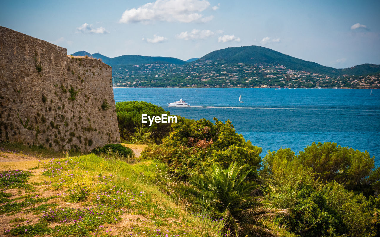 SCENIC VIEW OF SEA BY MOUNTAIN AGAINST SKY