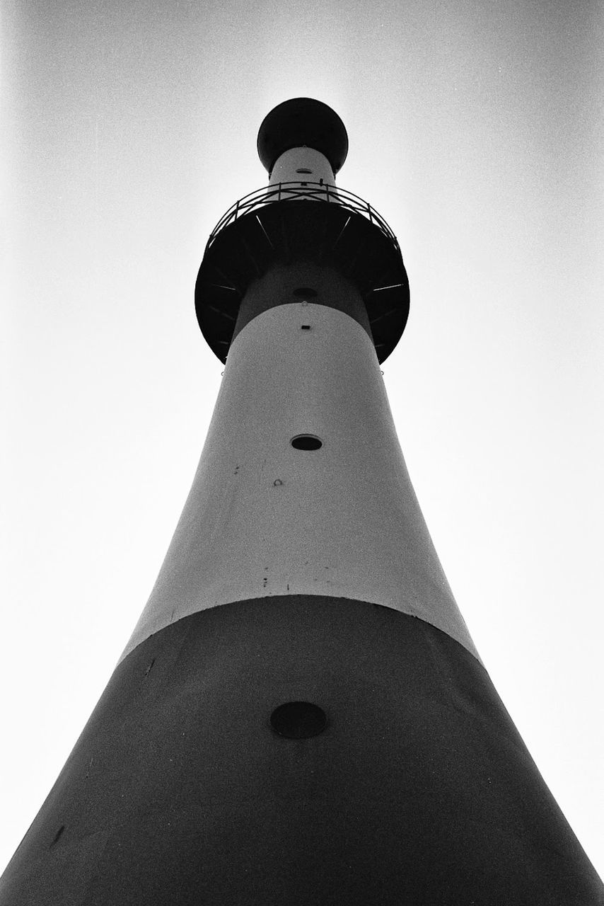 Low angle view of a lit lighthouse against clear sky