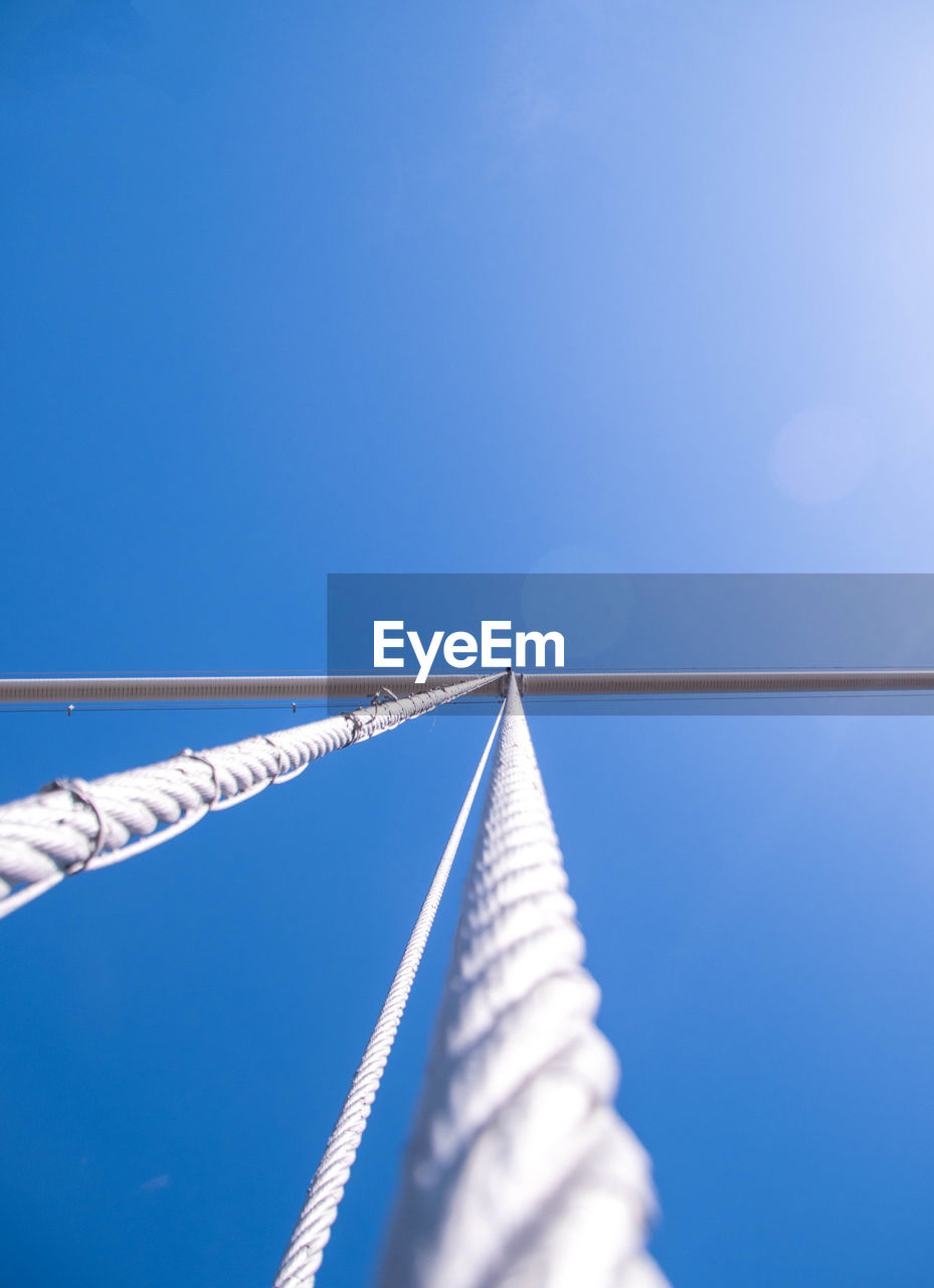 LOW ANGLE VIEW OF ROPES AGAINST BLUE SKY