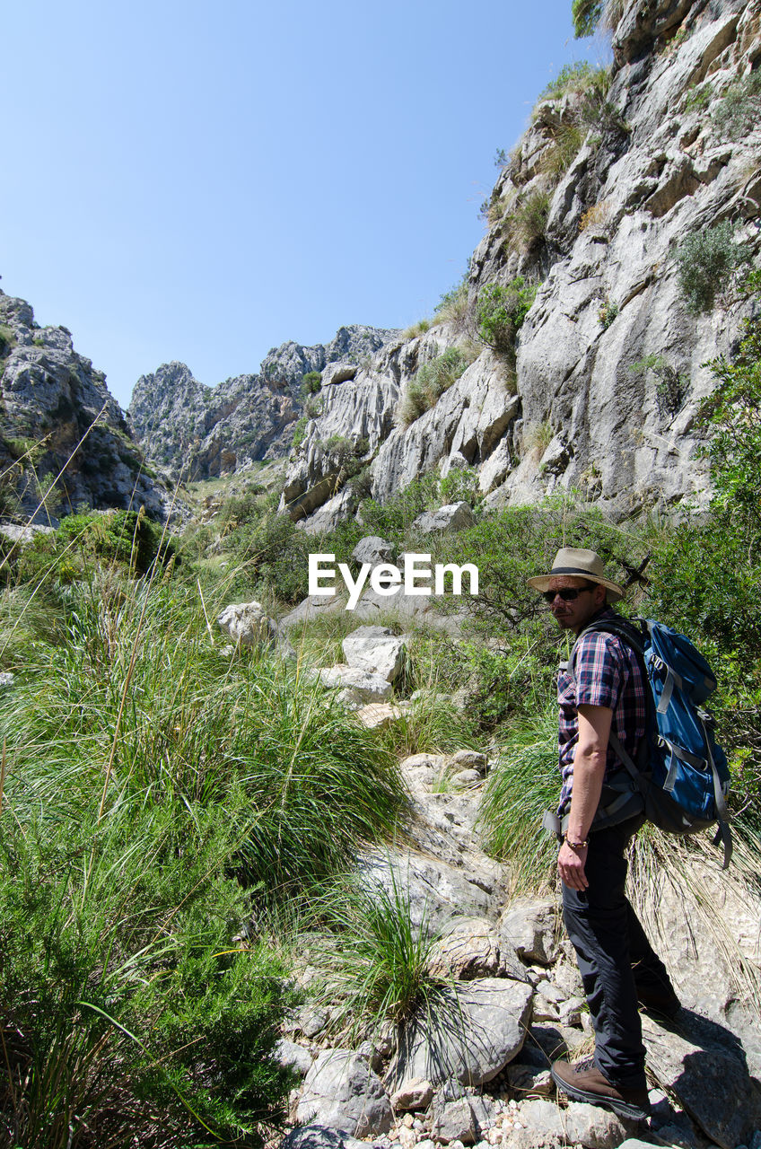 Side view of young man hiking on .mountain in forest