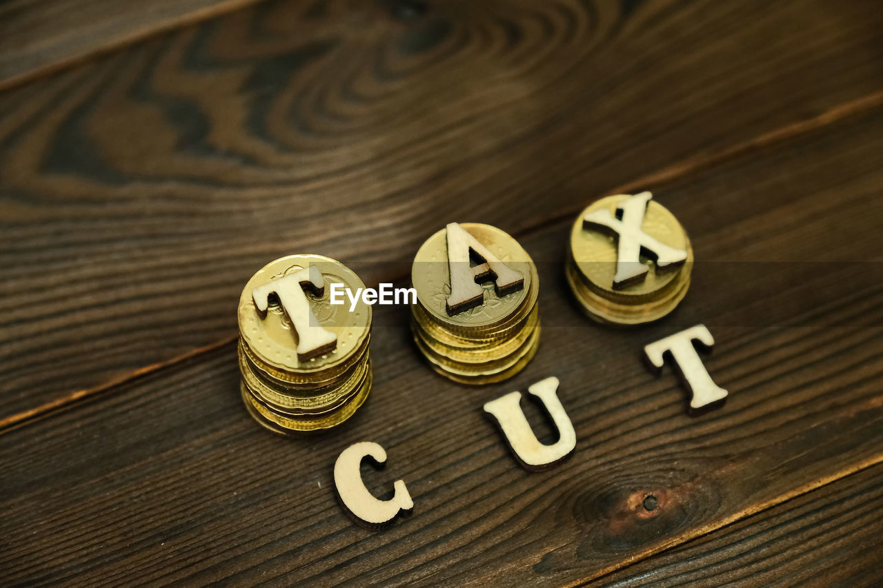 High angle view of coins with tax cut text on table