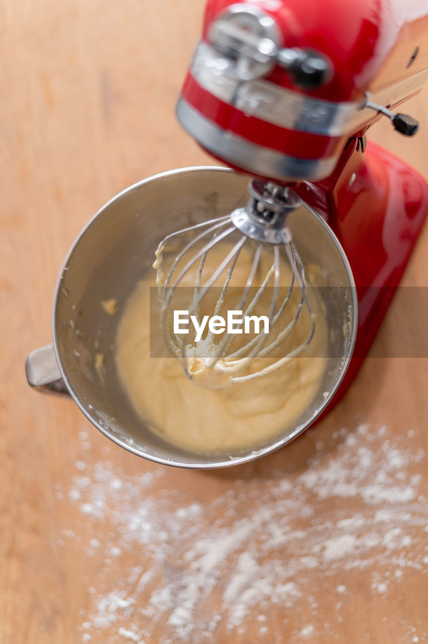 food and drink, food, indoors, wood, kitchen utensil, dessert, mixer, icing, high angle view, sweet food, freshness, dish, wire whisk, batter, no people, domestic room, household equipment, produce, table, close-up, baked, kitchen, home, bowl, ingredient