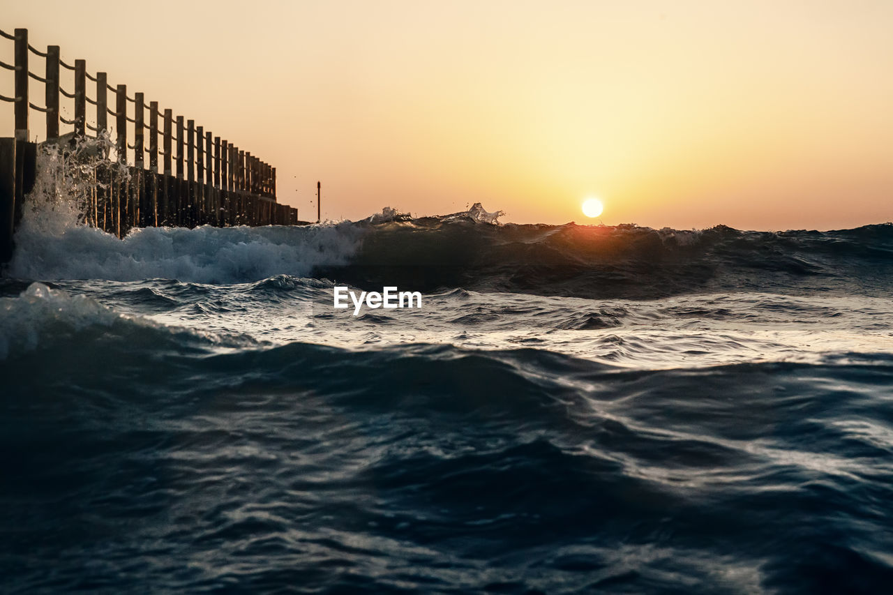 Scenic view of sea against clear sky during sunset