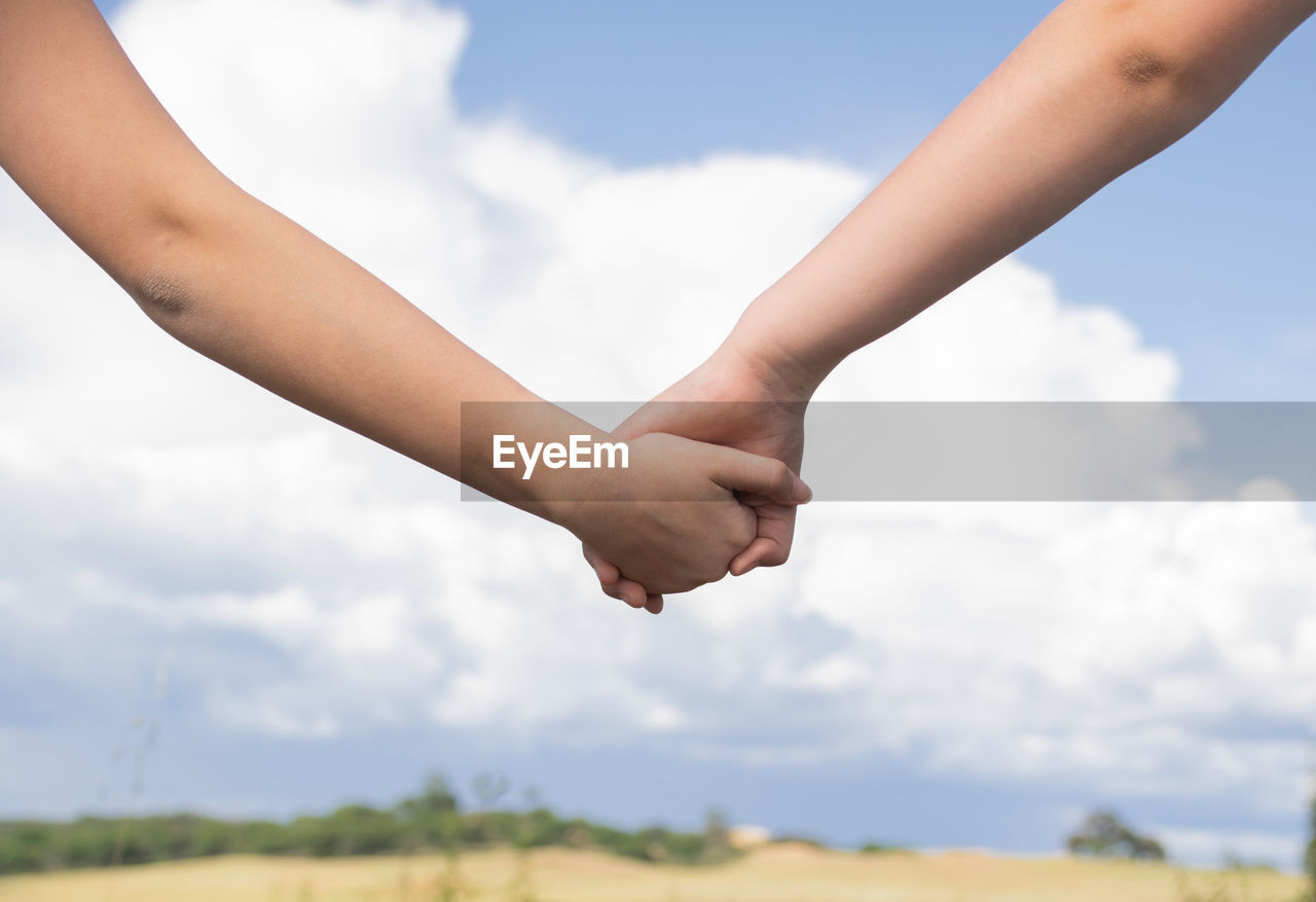 Helping hand between two brothers in the background of the blue sky, family