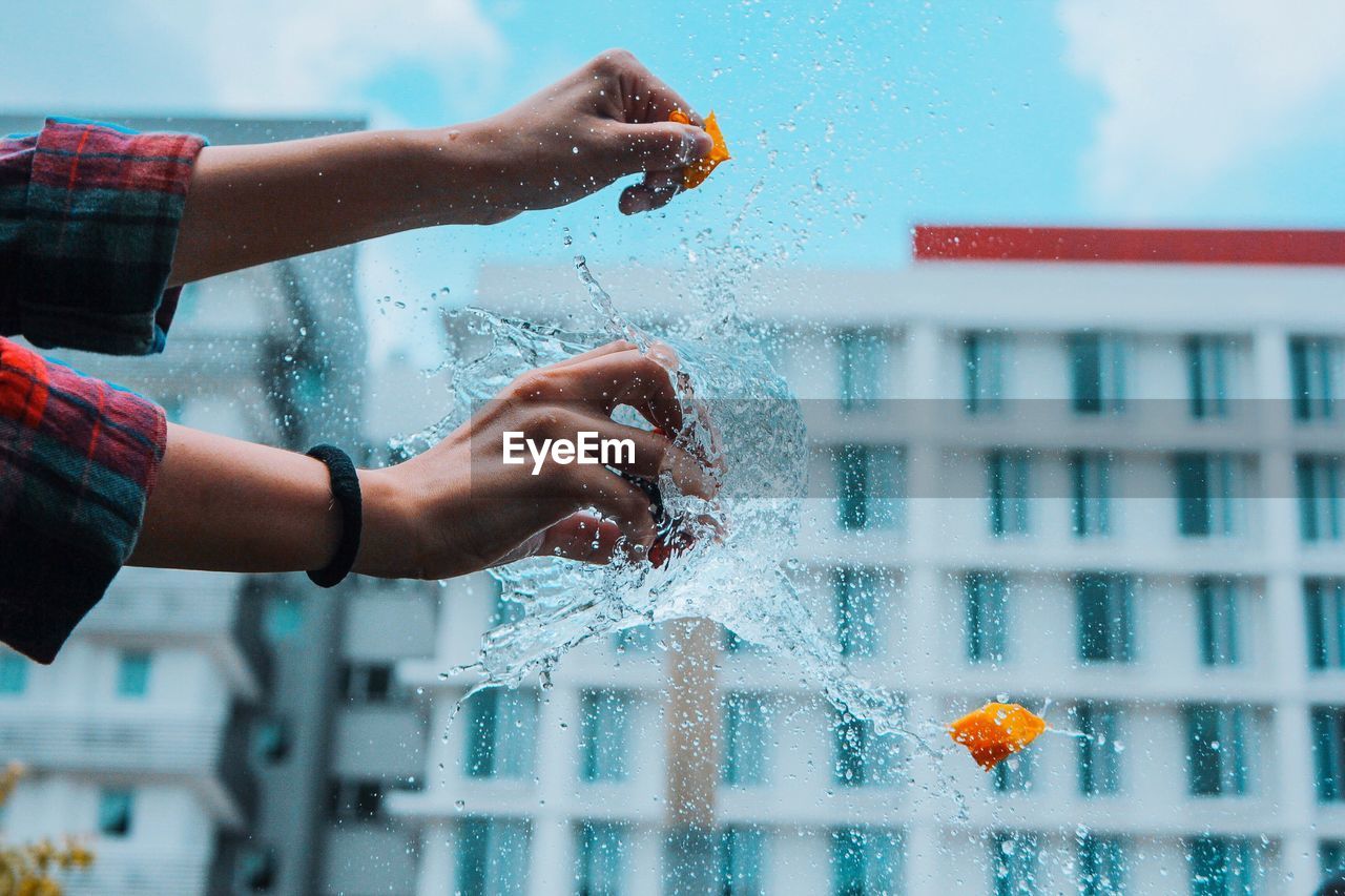 Cropped image of woman bursting water bomb