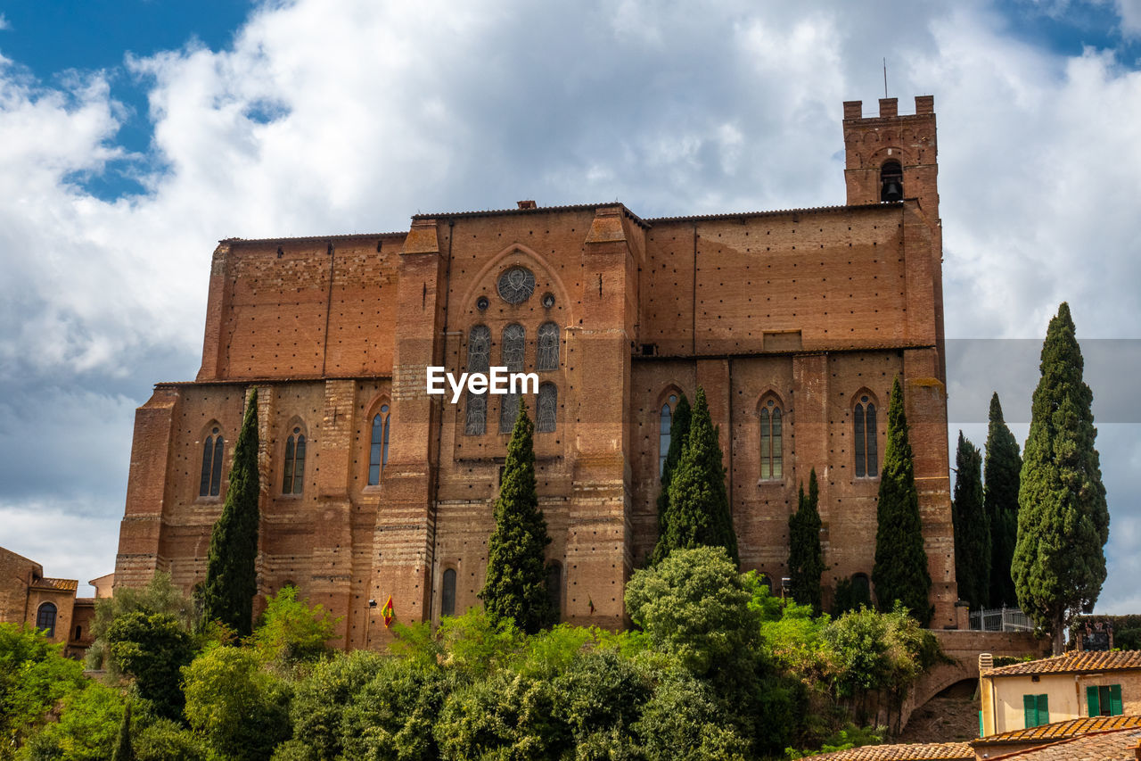 Low angle view of historical building, san domenico  basilica in siena, italy, against sky