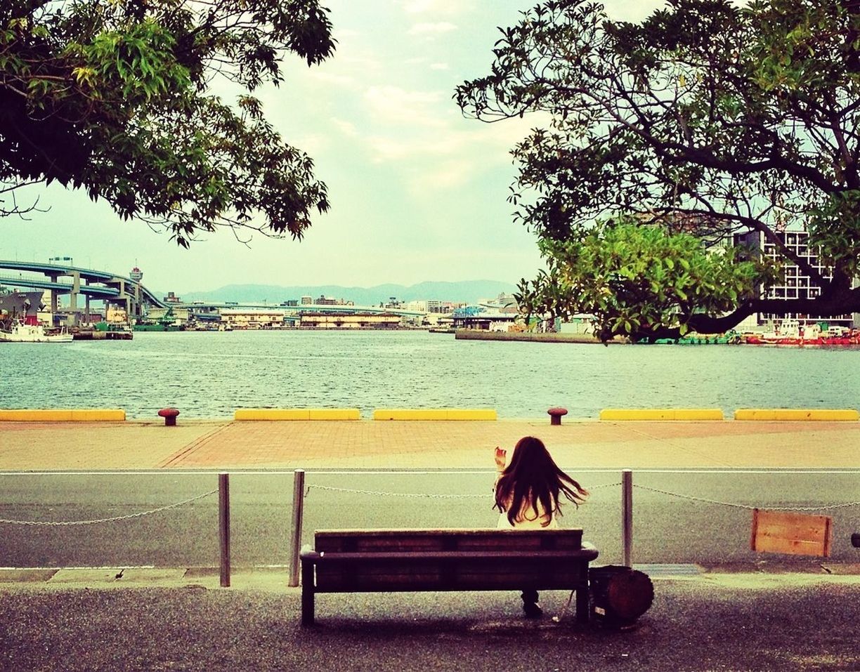 Rear view of woman overlooking calm river