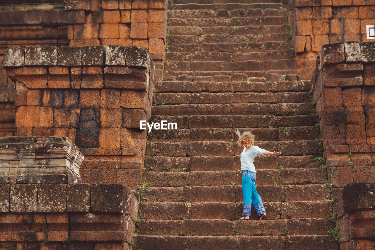 Side view of mid adult woman standing on steps