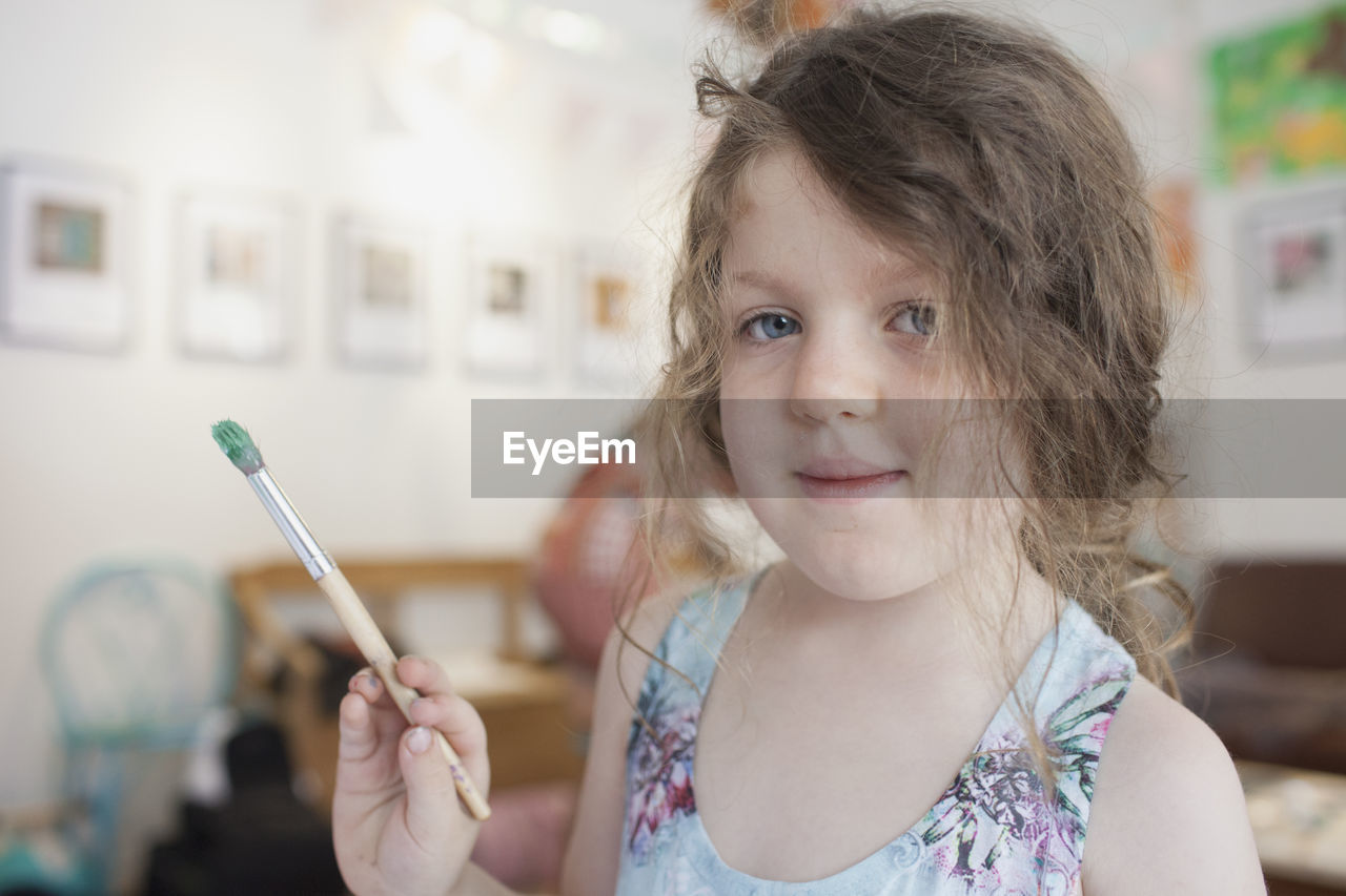 A girl holding a paintbrush