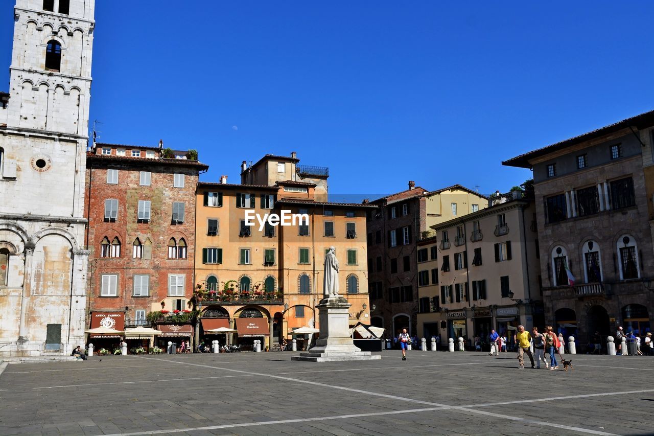 PEOPLE IN CITY AGAINST BLUE SKY