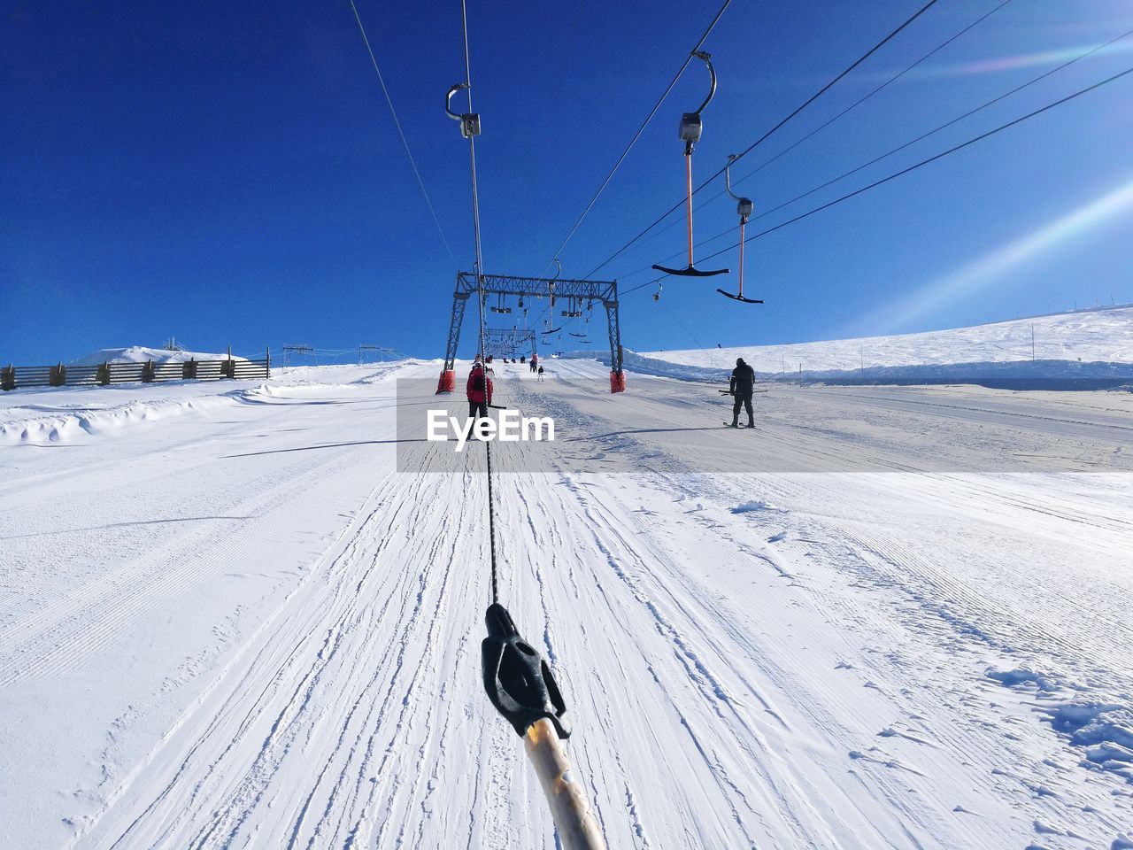 People skiing on snow against blue sky