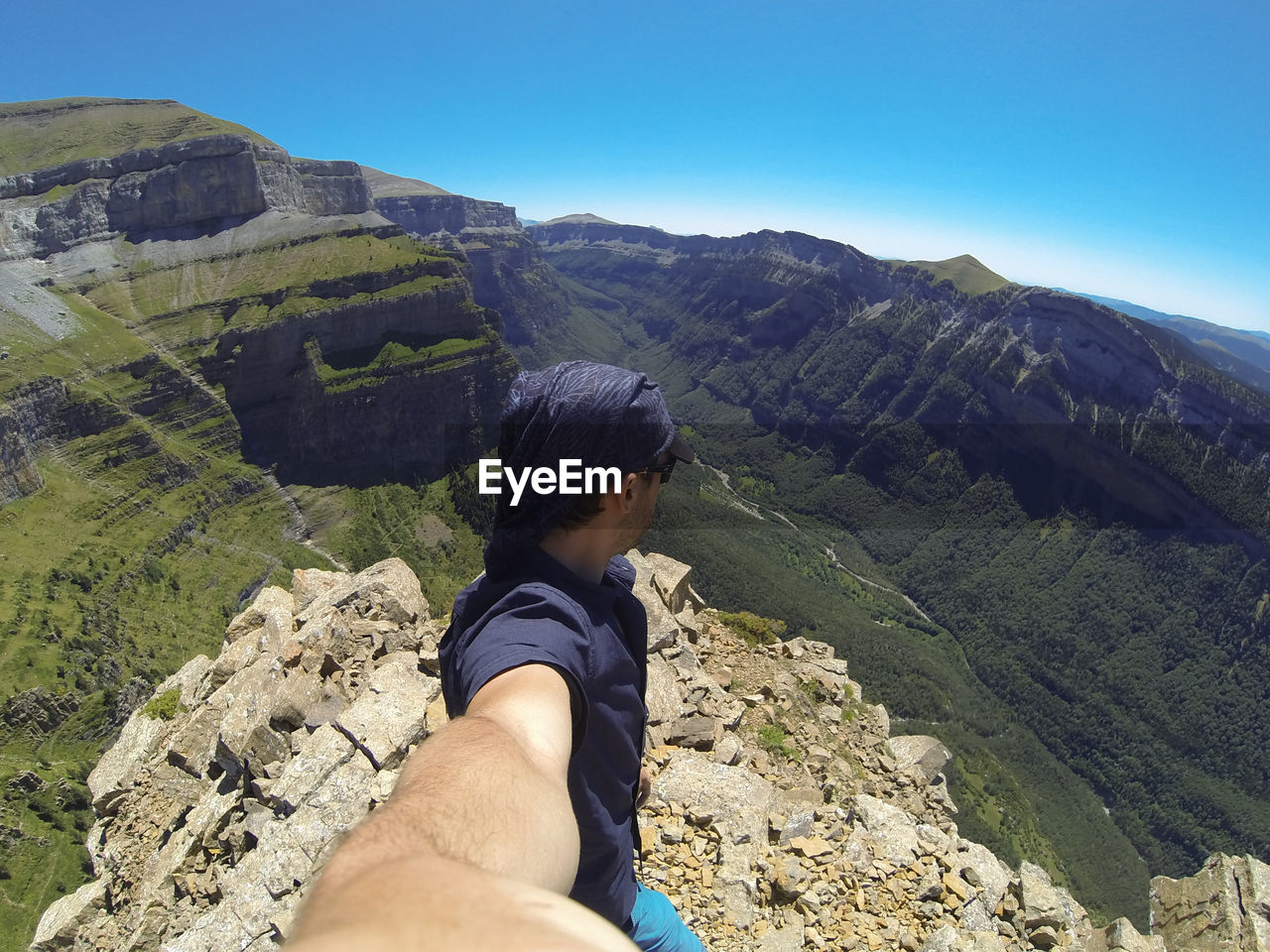 Midsection of man looking at mountain range against sky