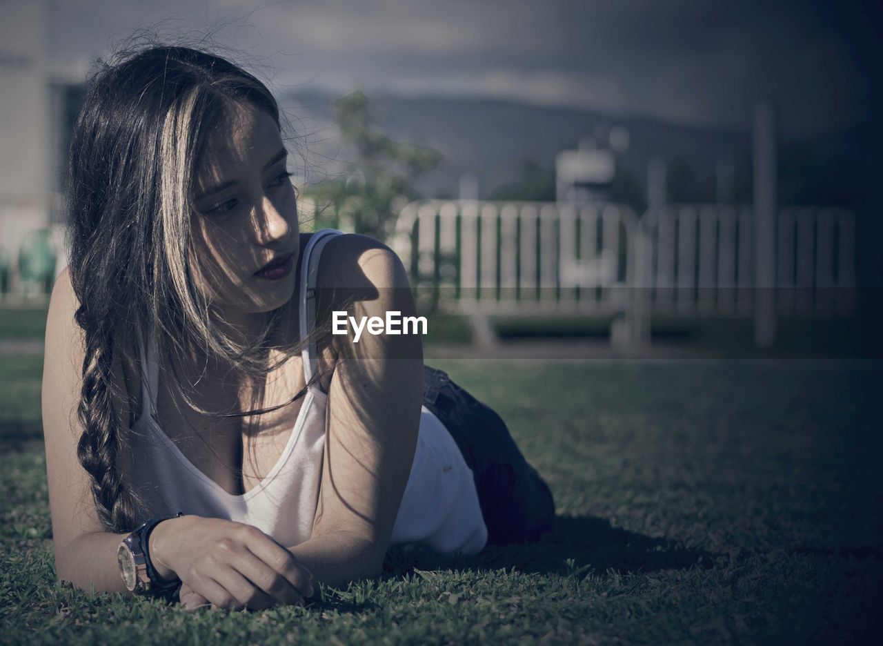 Young woman lying on grassy field