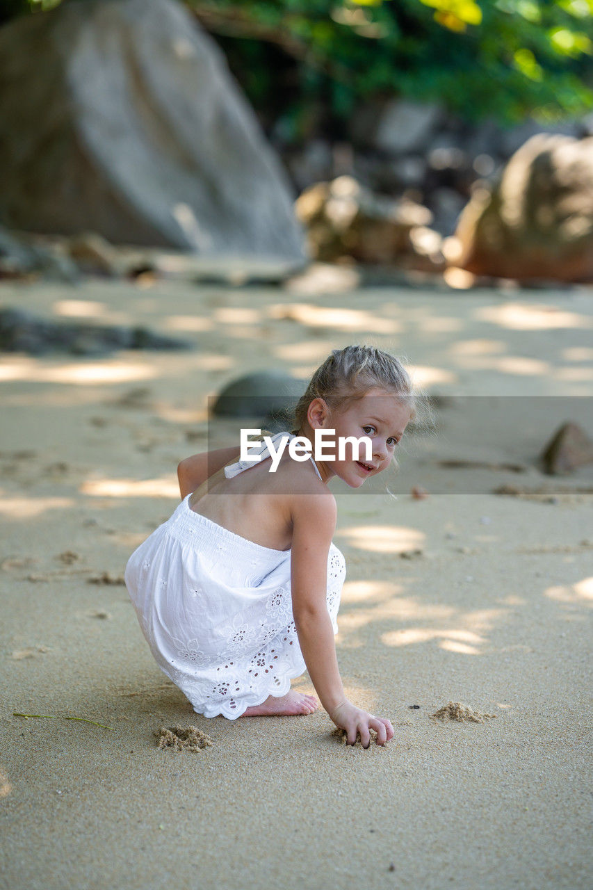 side view of young woman standing at beach