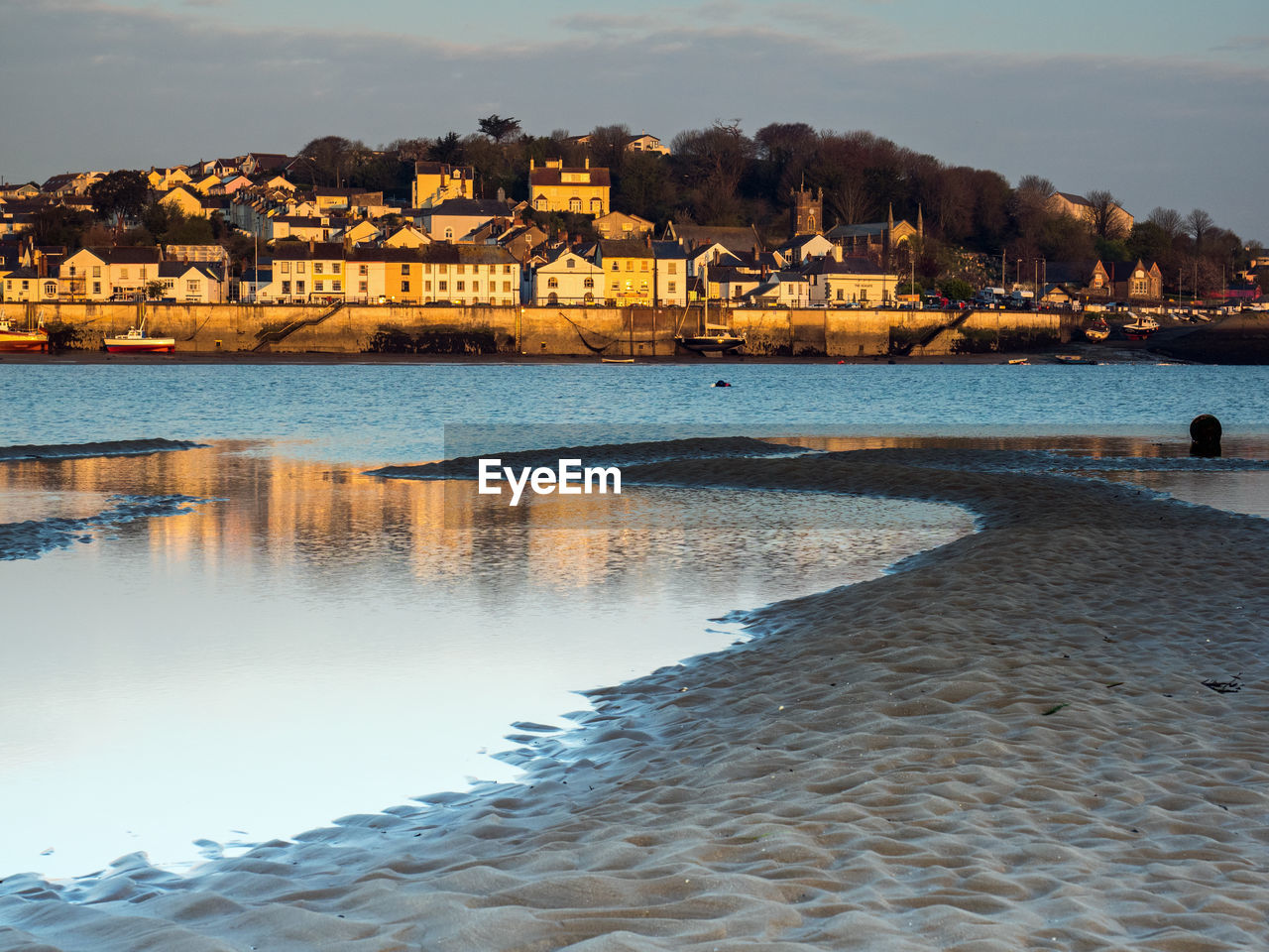 Scenic view of sea by buildings against sky