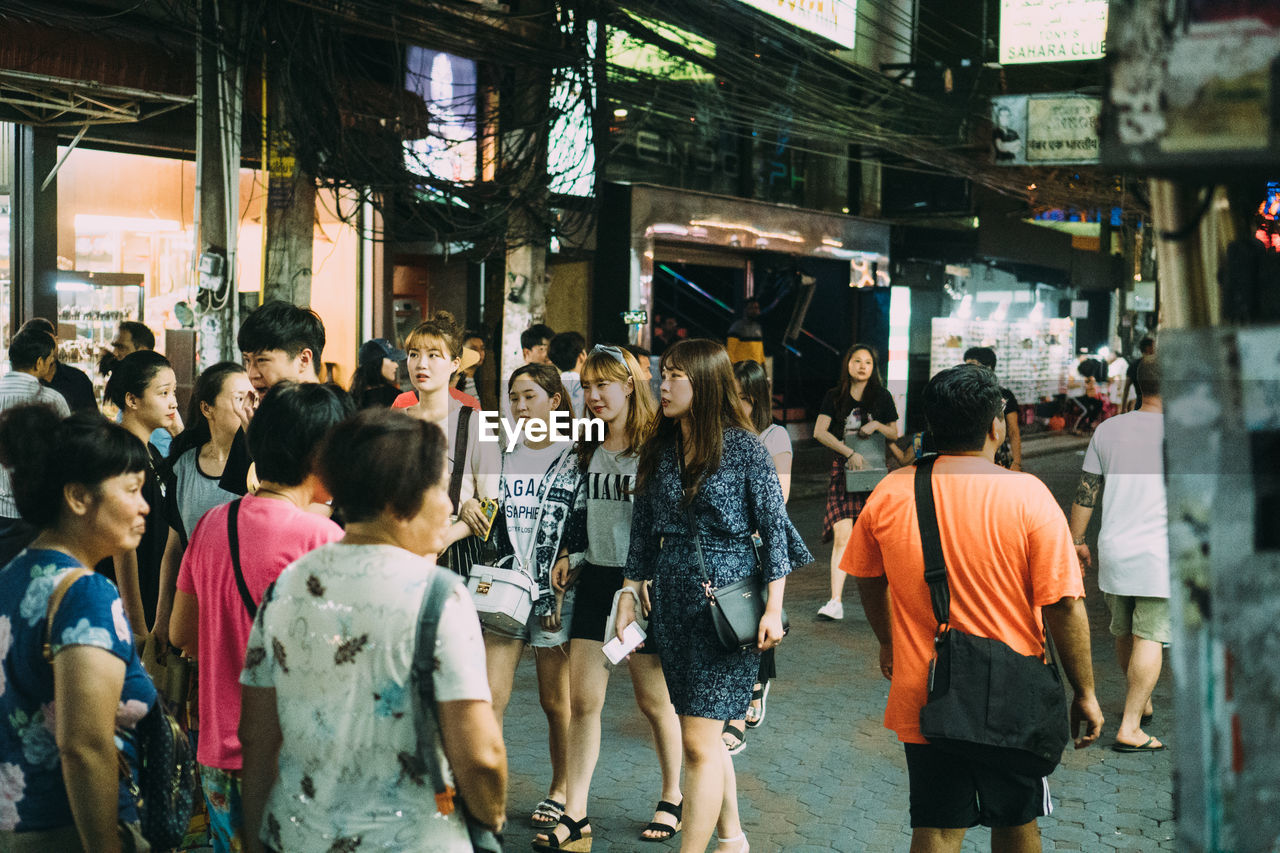 GROUP OF PEOPLE WALKING ON STREET