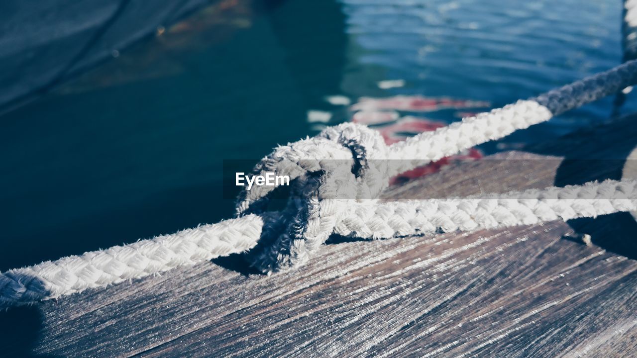 Close-up of tied rope on boat at harbor