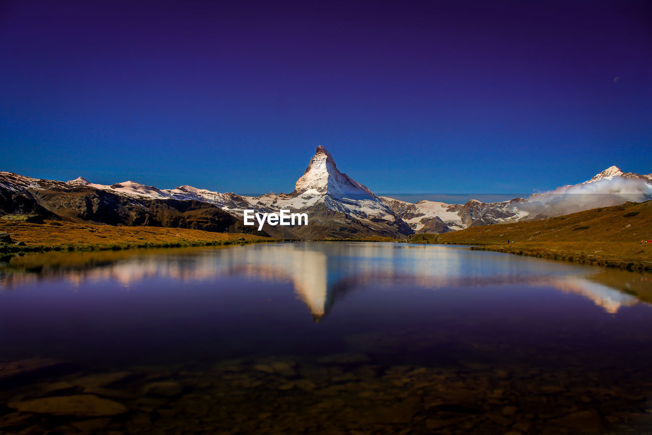 Scenic view of lake and mountains against clear sky