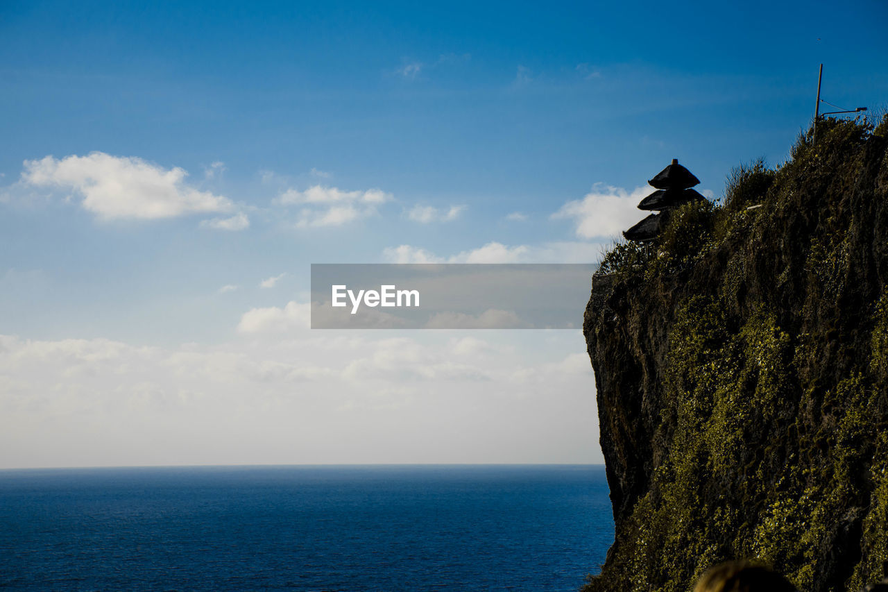 VIEW OF SEA BY ROCK AGAINST SKY