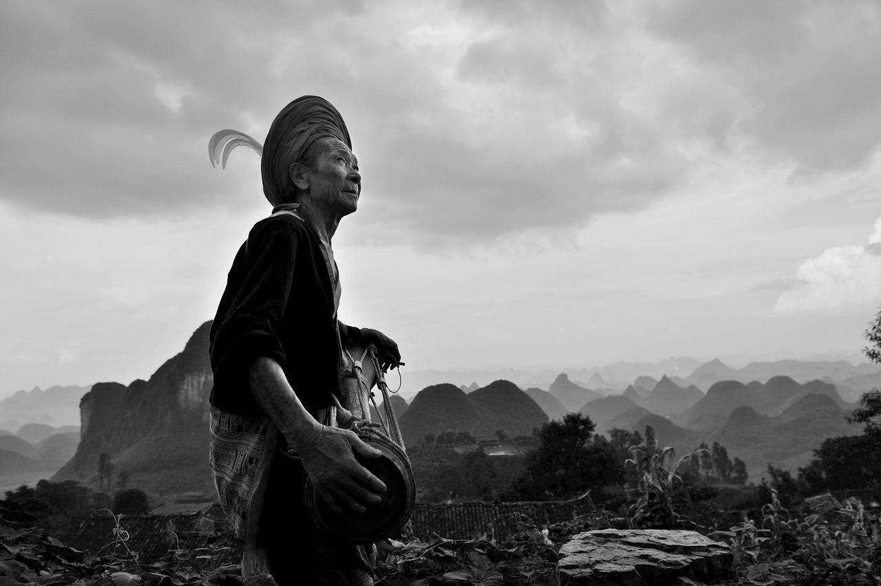 Low angle view of man playing musical instrument while standing against sky