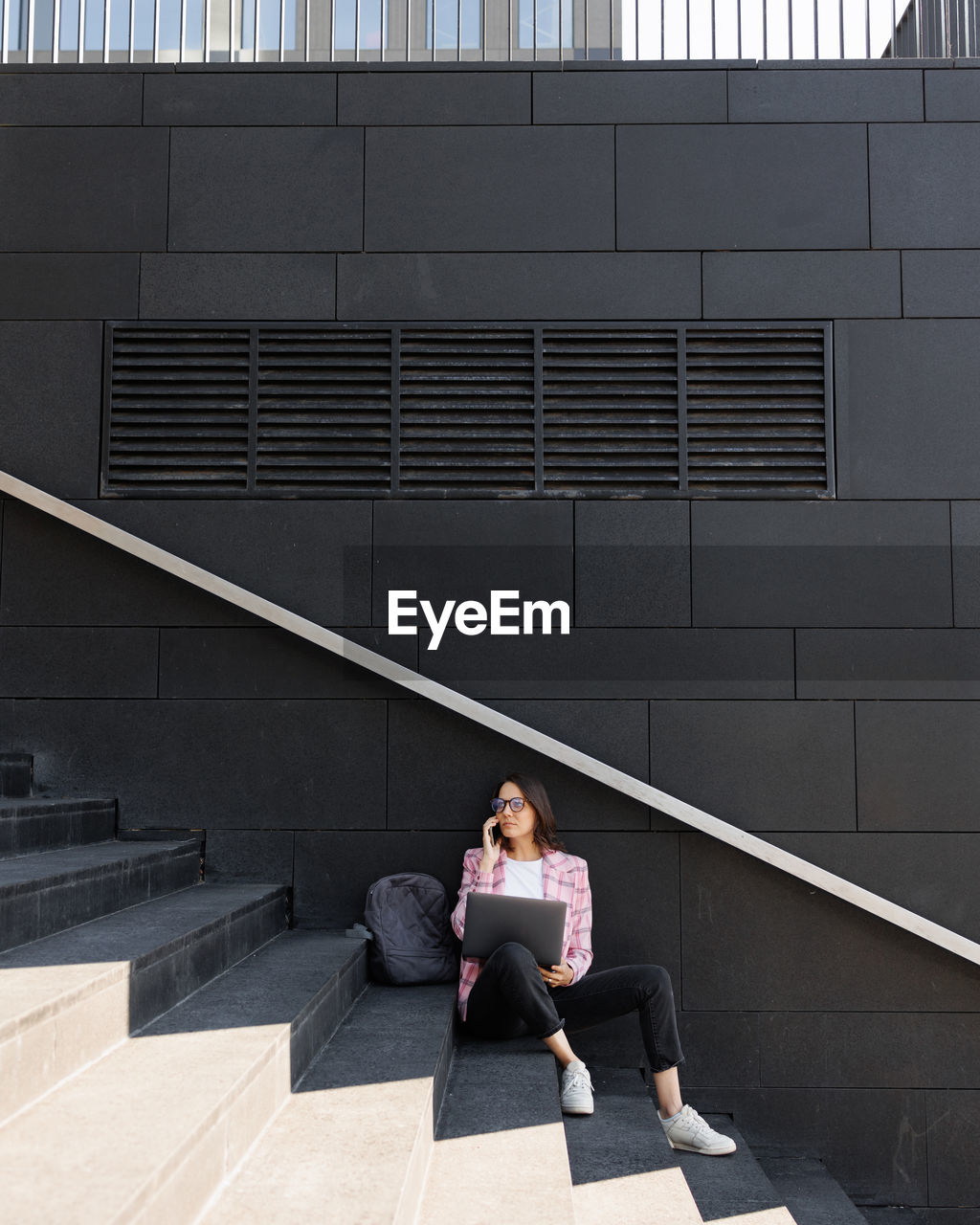 low angle view of boy sitting on staircase in building