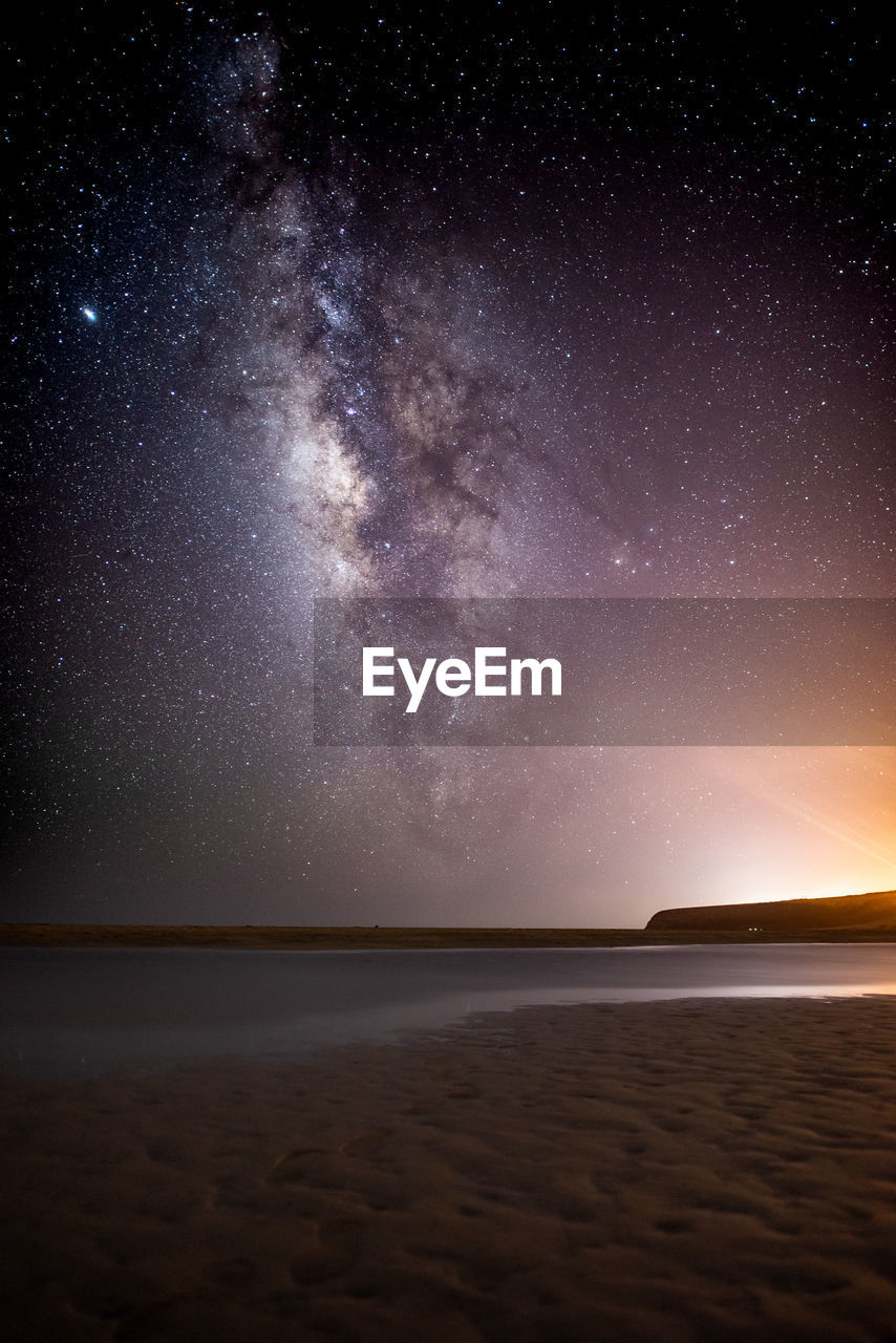 SCENIC VIEW OF BEACH AGAINST SKY AT NIGHT