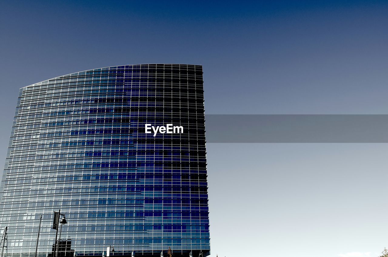 Low angle view of modern building against clear blue sky