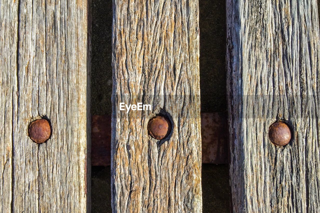 Close-up of rusty metallic screws on weathered wooden planks