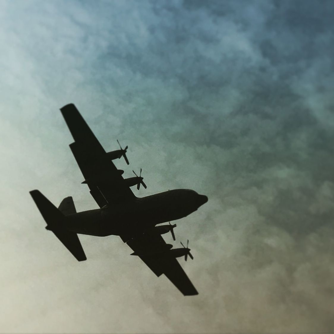 Low angle view of airplane flying in cloudy sky