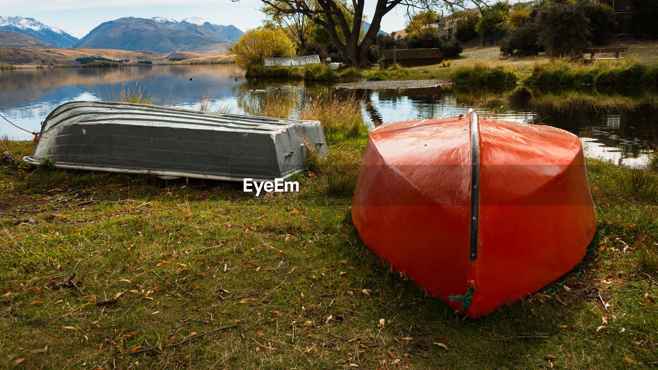 RED BOAT MOORED ON FIELD