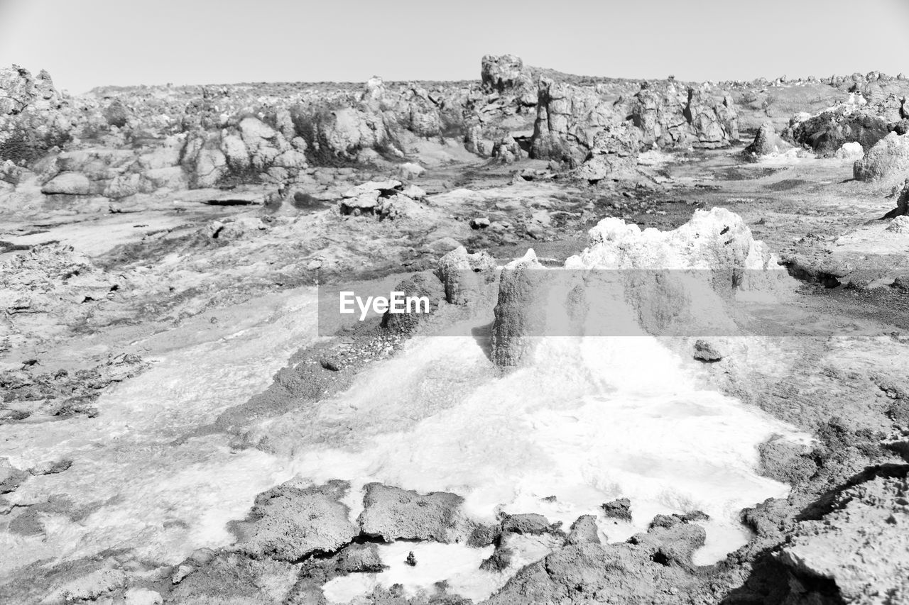 SCENIC VIEW OF ROCKY SHORE AGAINST SKY