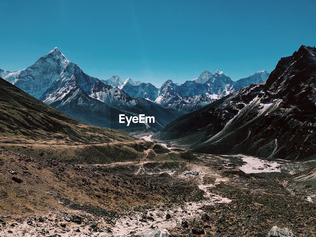 Scenic view of snowcapped mountains against blue sky