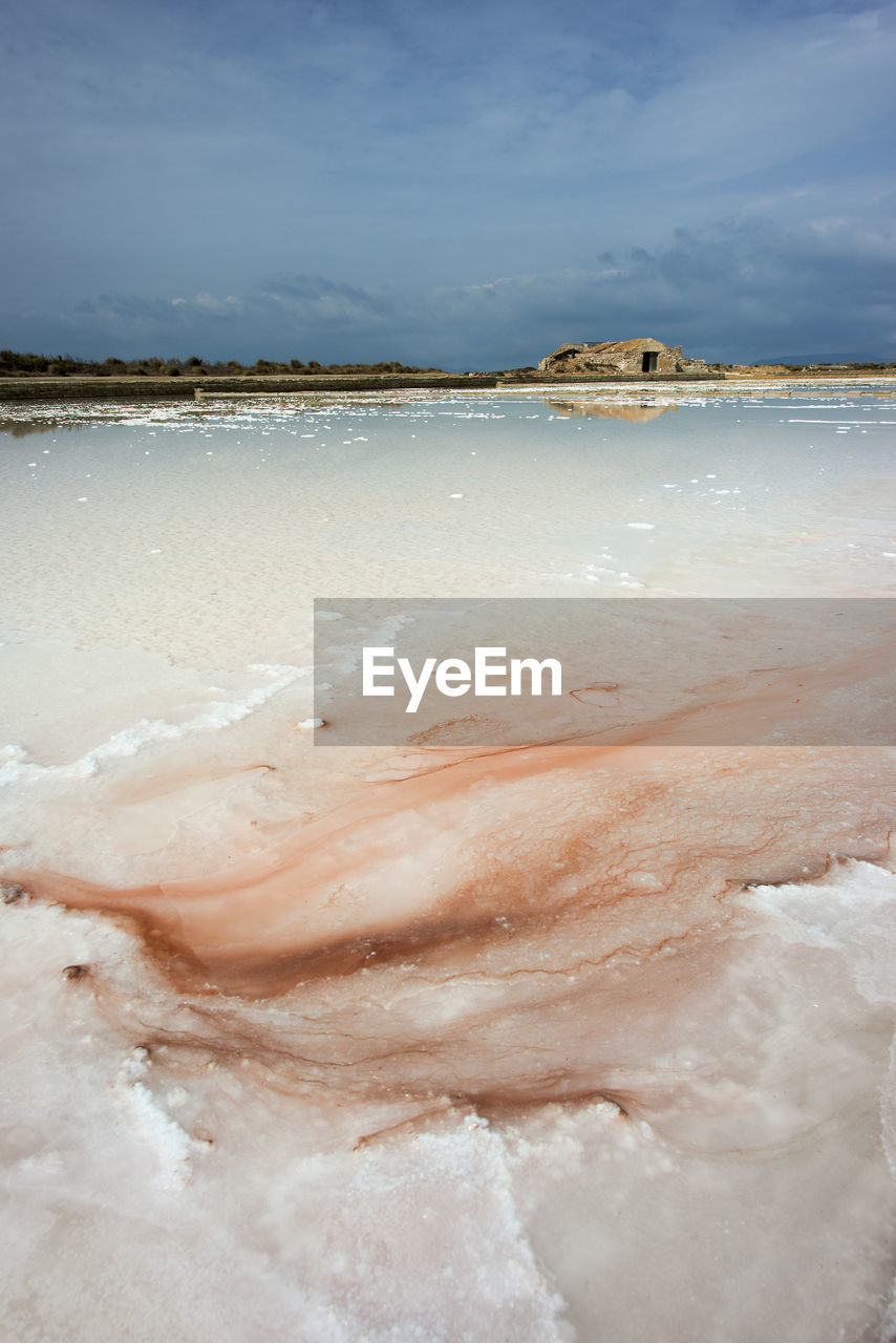 Salt flats against sky on sunny day