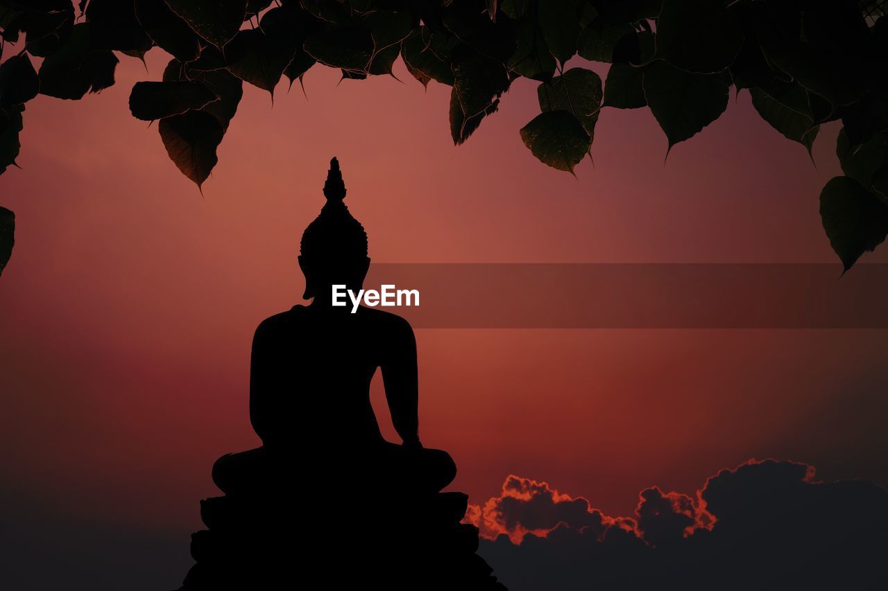 Low angle view of silhouette statue against sky during sunset