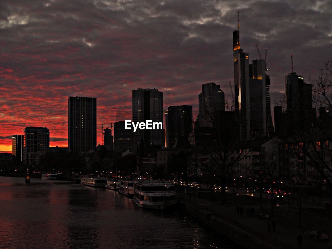 Illuminated buildings in city against sky at sunset