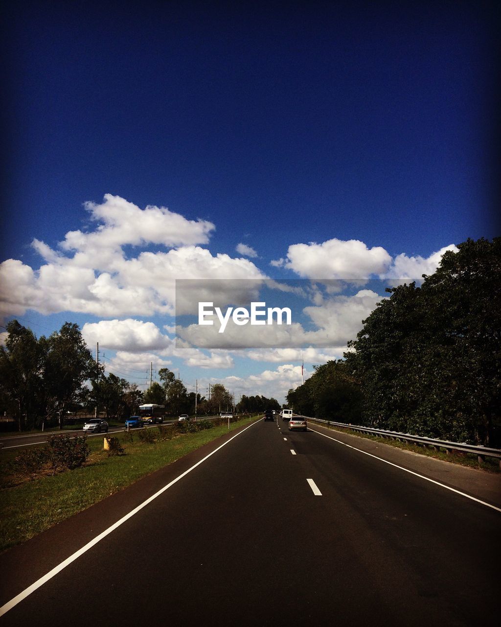 Empty road against cloudy sky