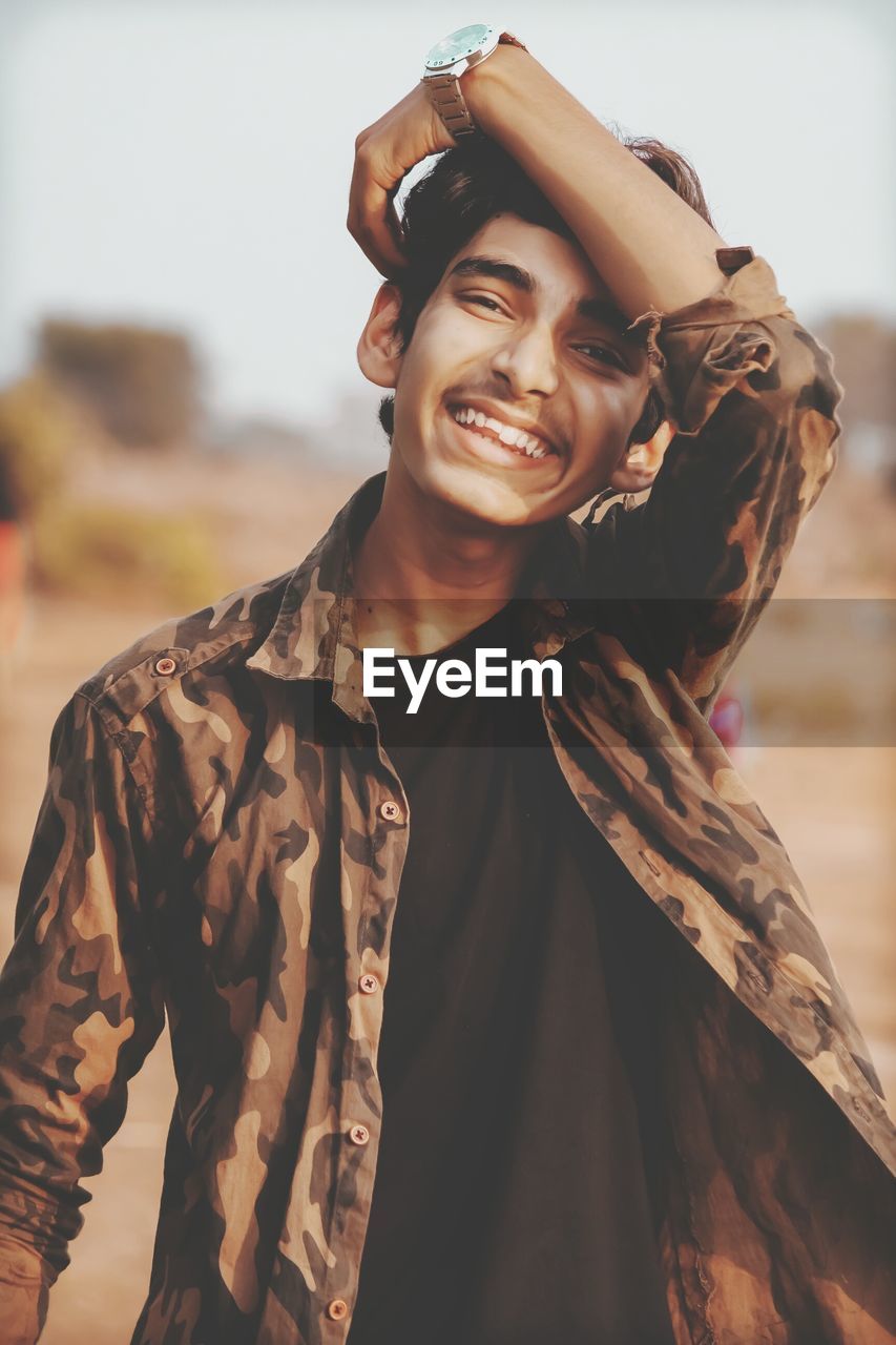 Portrait of smiling young man standing outdoors