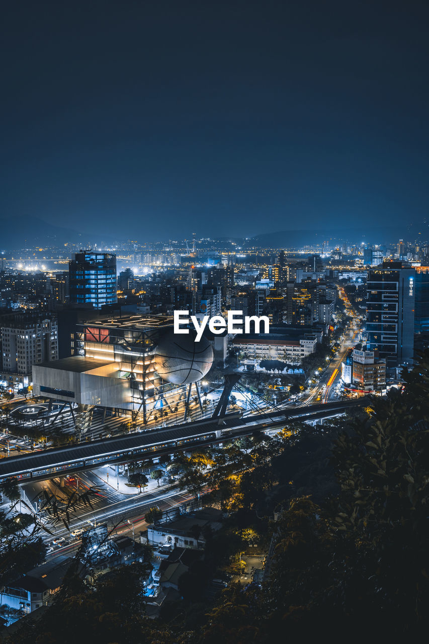 Illuminated cityscape against sky at night