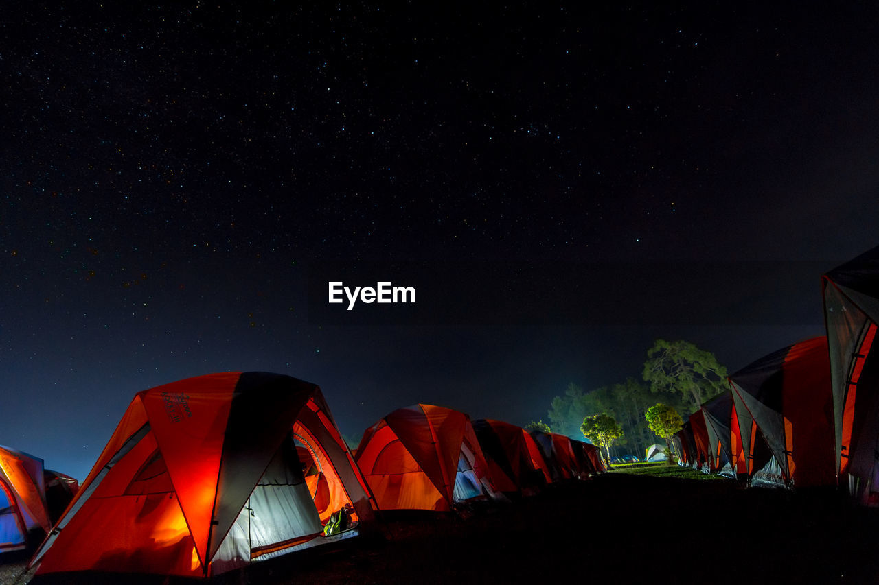 The orange tent under night sky and stars. location place phu kra dueng national park of thailand.