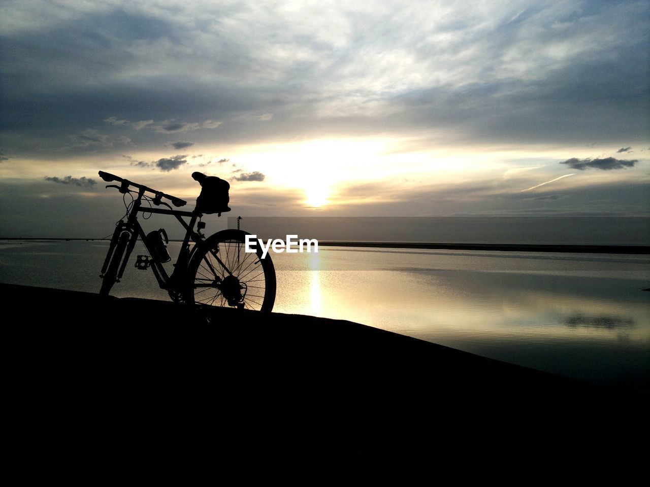 Scenic view of sea and bike at sunset