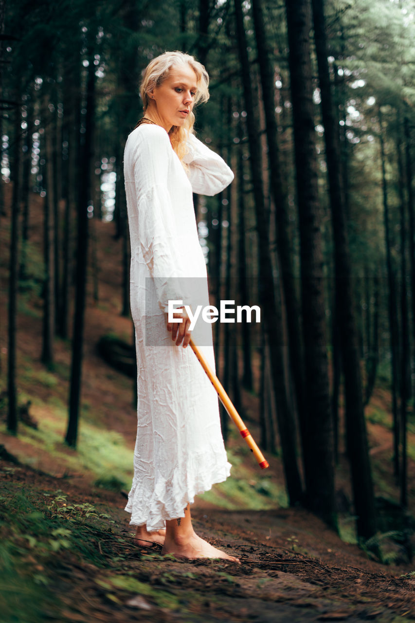 Portrait of young woman standing in forest