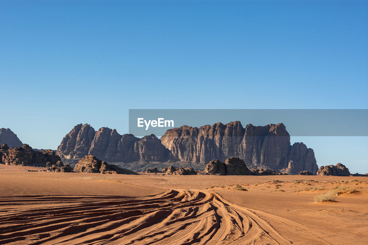 Panoramic view of desert landscape against clear blue sky