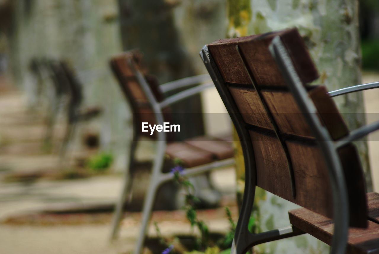 Row of wooden chairs on sidewalk