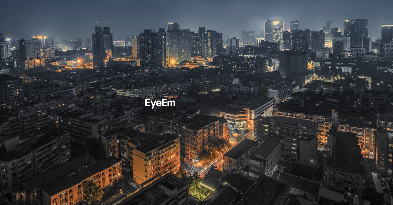 Aerial view of illuminated cityscape against sky at night